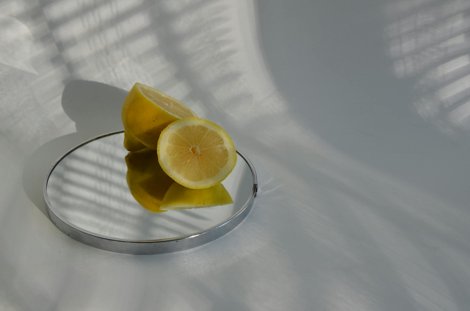Hand holding a lemon on soft pink background, symbolizing slow, intentional pleasure and self-care