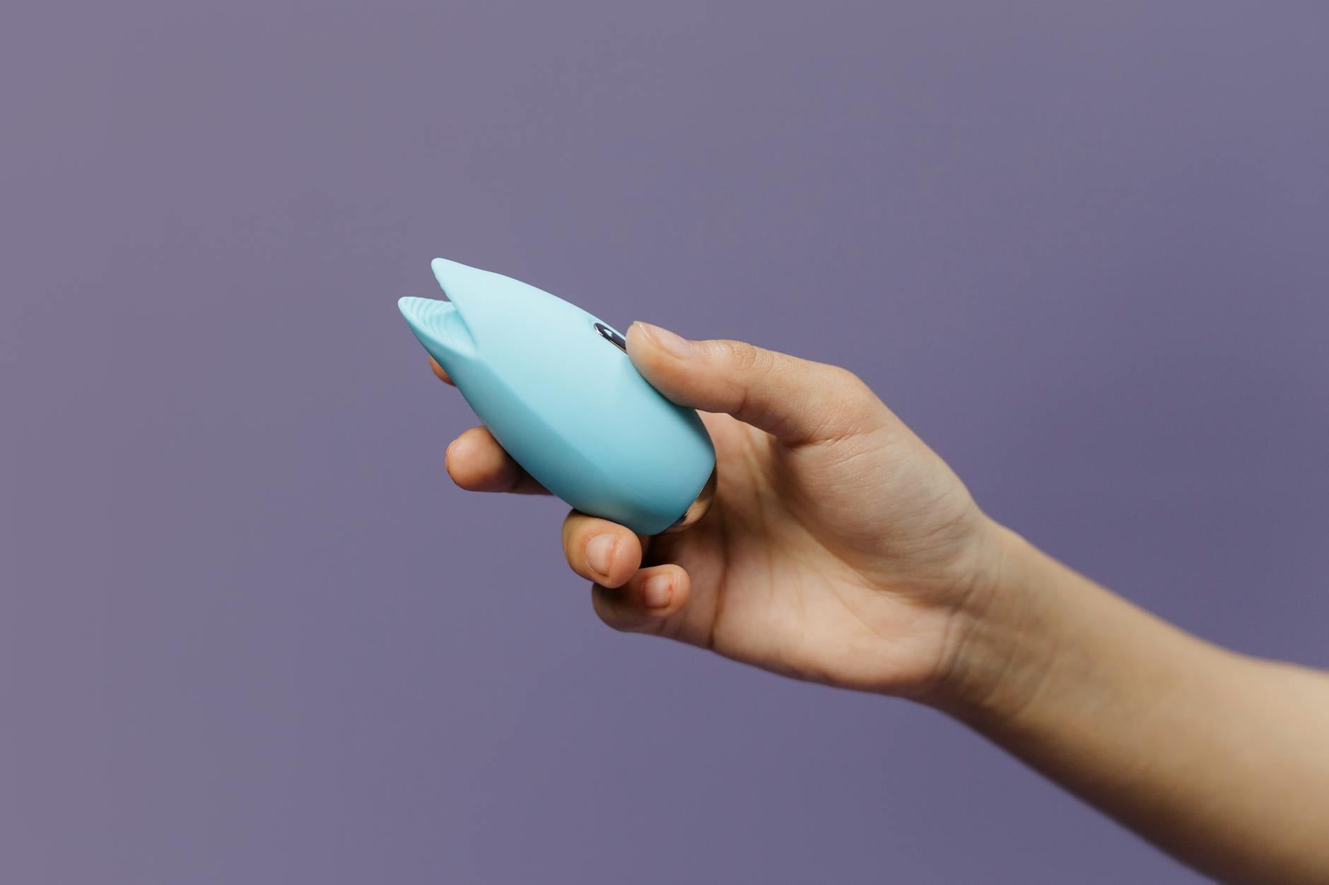 Vibrant collection of colorful clitoral vibrators and sex toys on bright yellow background