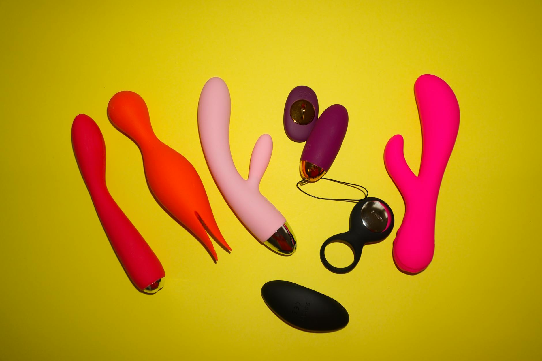 Colorful vibrators arranged on a bright yellow background